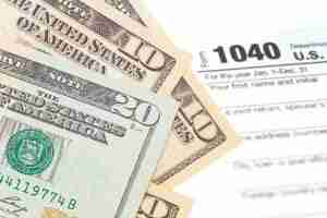 Money laid over the top of a tax refund form