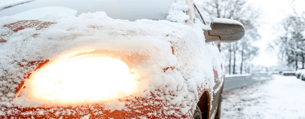 Don't Let the Winter Months Freeze Out Your Sales 12 Red car frozen over in the snow with lights on.